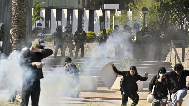 <p>Demonstranten fliehen vor der Polizei, die Tränengas und Blendgranaten vor dem Bundesgebäude in Santa Ana (Kalifornien) einsetzt.</p>