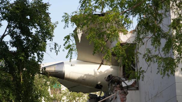 <p>Die Trümmer eines Flugzeugs ragen aus einem Gebäude, nachdem es in der nordwestlichen Stadt Ahmedabad im indischen Bundesstaat Gujarat abgestürzt ist.</p>