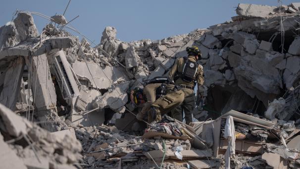 <p>Rettungskräfte begutachten die Schäden und suchen nach Opfern, nachdem eine iranische Rakete in Rishon Lezion eingeschlagen ist.</p>