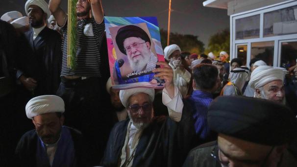 <p>Ein irakischer schiitischer Geistlicher hält in Bagdad während eines Protestes gegen israelische Angriffe auf mehrere Städte ein Porträt des Obersten Führers des Iran, Ayatollah Ali Chamenei, hoch.</p>