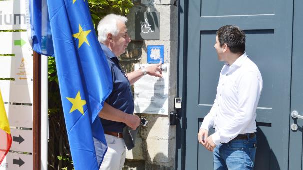 <p>Gerhard Laux, Vorsitzender der „Via Democratia Europa e.V.“präsentiert dem Malmedyer Tourismusschöffen Mathieu Bronlet die neue Plakette am Eingang des Malmundariums.</p>