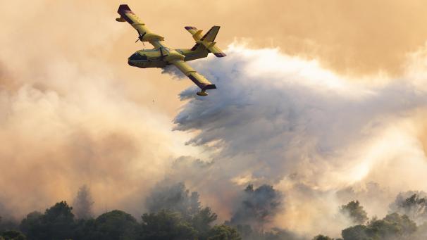 <p>Ein Löschflugzeug versprüht Wasser, um einen Waldbrand auf der Insel Ciovo zu löschen.</p>
