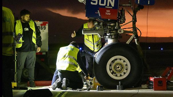 <p>Arbeiter kümmern sich um ein mechanisches Problem bzw. einen Reifenschaden an dem für den König gecharterten Flugzeug.</p>