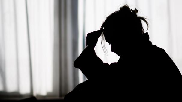 <p>Die Silhouette einer Frau zeichnet sich vor einer hellen Fensterfront ab.</p>