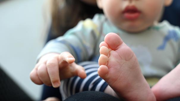 <p>Ein Baby, das auf dem Schoß seiner Mutter sitzt, zeigt mit der Hand nach vorne. Eine Harvard-Studie kommt zur Annahme, dass das Alter und die Gene der Mütter die Geschlechtsverteilung in der Familie beeinflussen.</p>