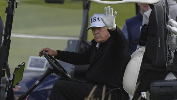 <p>US-Präsident Donald Trump winkt Reportern zu, während er in seinem Golfwagen auf dem Trump Turnberry Golfplatz in Schottland, sitzt.</p>