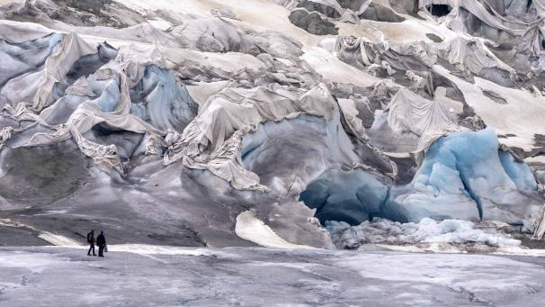 <p>Mitarbeiter des ETH-Glaziologen und Leiters des Schweizer Messnetzes «Glamos», Matthias Huss, am teilweise bedeckten Rhonegletscher in der Nähe des Goms in der Schweiz. Das Foto stammt aus dem Juni 2023.</p>