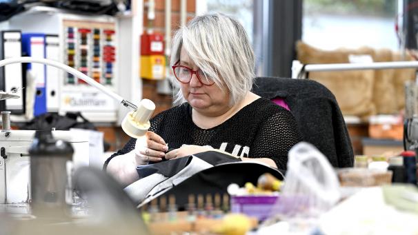 <p>In der Werkstatt fertigen Mitarbeiterinnen seit Jahrzehnten mit viel handwerklichem Geschick hochwertige Produkte – vom einfachen Kissen bis zur maßgeschneiderten Tasche.</p>