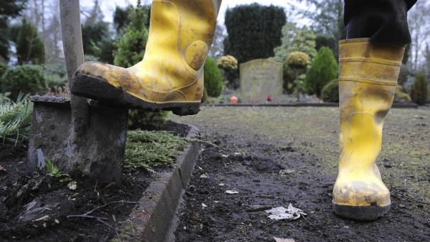 <p>Ein Spaten steckt in einem Grab auf einem Friedhof: Für 611.000 Euro werden in Verviers nun 74 neue Grabstellen geschaffen.</p>