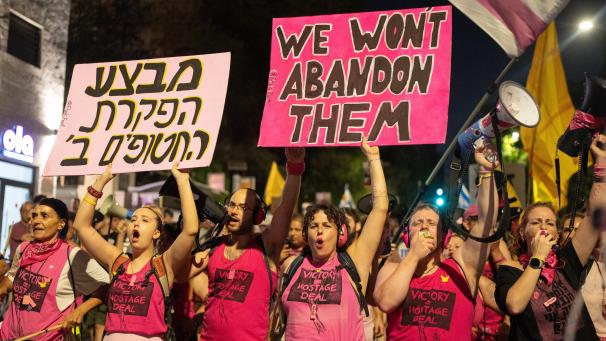 <p>Israelis halten während eines Marsches in Jerusalem Schilder und fordern einen Waffenstillstand, die Freilassung der Geiseln und ein Ende des Krieges.</p>