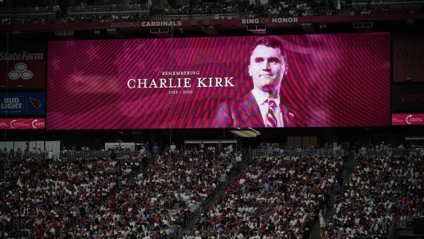 <p>Ein Foto des konservativen Aktivisten Charlie Kirk ist auf einem großen Bildschirm während der Trauerfeier im State Farm Stadium zu sehen.</p>