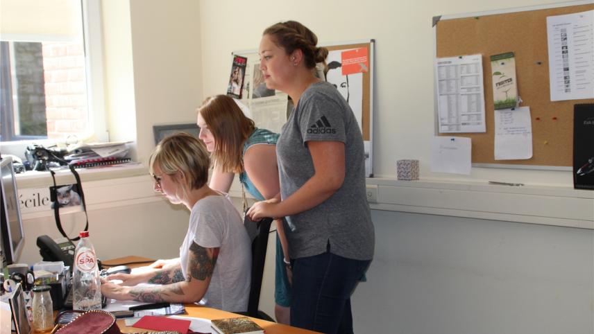 <p>Dieses Foto entstand bei einem früheren „Media &amp; Me“-Projekt in der GrenzEcho-Redaktion. Zwei junge Teilnehmerinnen schauen unserer Online-Redakteurin Annick Meys bei der Arbeit über die Schulter.</p>