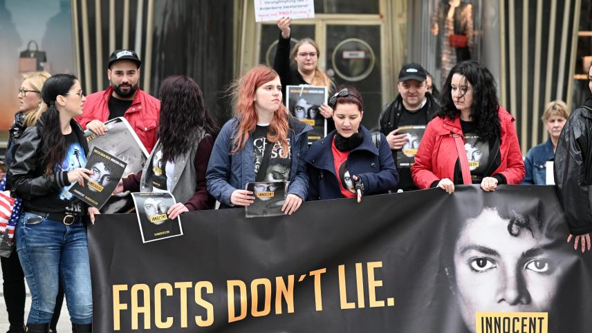 <p>Fans protestieren mit einem Banner mit der Aufschrift „Facts don't lie“ (Fakten lügen nicht) und Plakaten gegen die Austrahlung der Dokumentation „Leaving Neverland“ über den Popstar Michael Jackson.</p>
