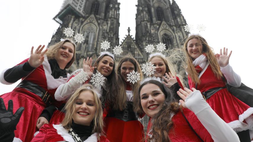 <p>Karnevalistinnen winken vor dem Kölner Dom.</p>
