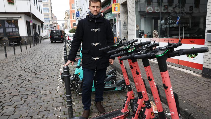 <p>Nico Rathmann, Fußgängerbeauftragter der Stadt Köln, steht in der Altstadt an einem Parkplatz für E-Scooter.</p>