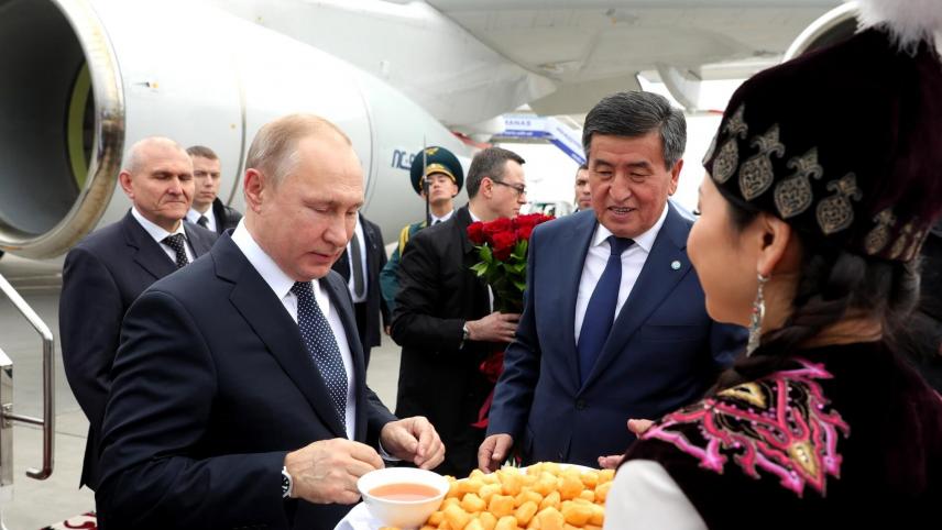 <p>Wladimir Putin (l), Präsident von Russland, wird von Sooronbai Dscheenbekow (mitte), Präsident von Kirgistan, am Flughafen Manas International begrüßt.</p>