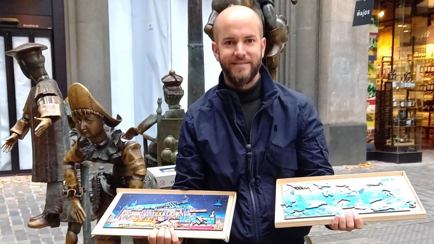 <p>Am Puppenbrunnen präsentiert Simon Gerads seine Aachener „Weihnachtsmarkt-Puzzle.“</p>
