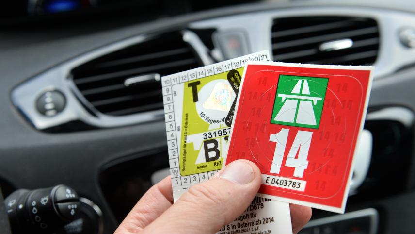 <p>Ein Autofahrer hält eine Schweizer Jahresvignette (rechts) in der Hand.</p>